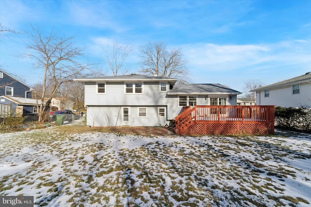 snow covered rear of property with a wooden deck