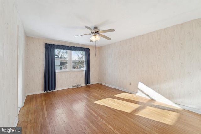 unfurnished room with ceiling fan and hardwood / wood-style floors