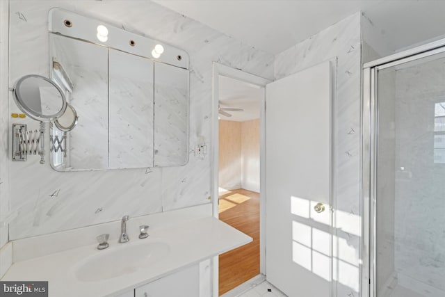 bathroom with tile patterned flooring, ceiling fan, a shower with shower door, and vanity