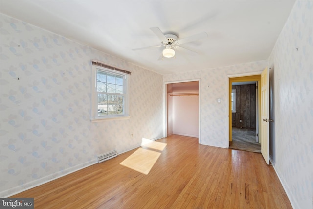 unfurnished bedroom featuring ceiling fan, light hardwood / wood-style floors, and a closet