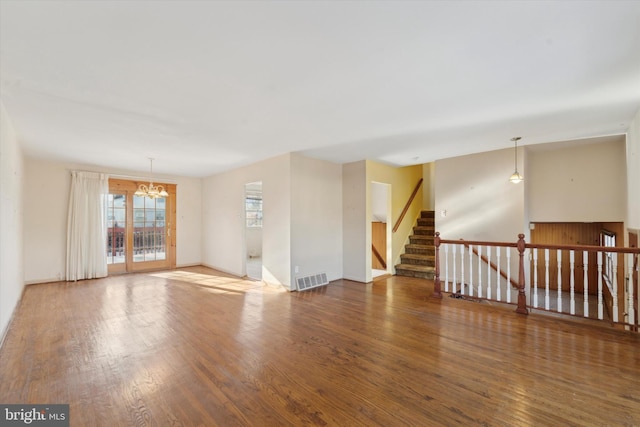 empty room featuring hardwood / wood-style flooring and an inviting chandelier