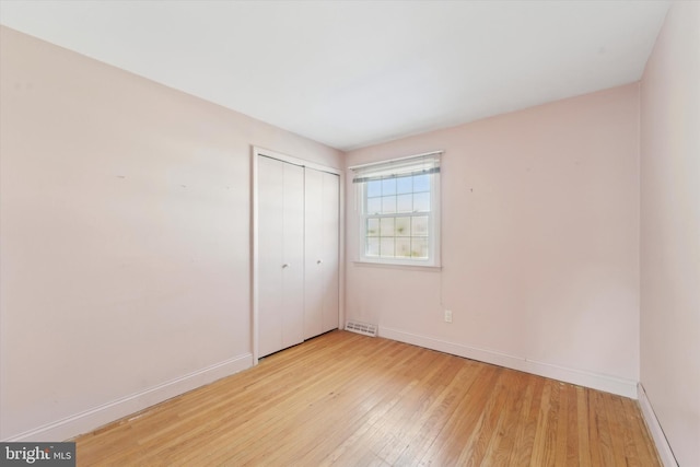 unfurnished bedroom featuring a closet and light hardwood / wood-style flooring