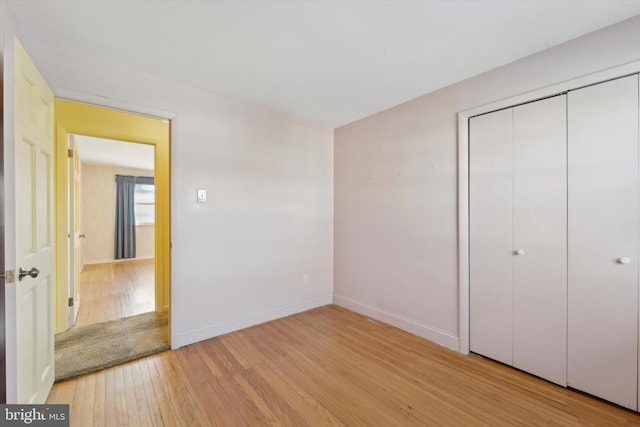 unfurnished bedroom featuring light hardwood / wood-style floors and a closet