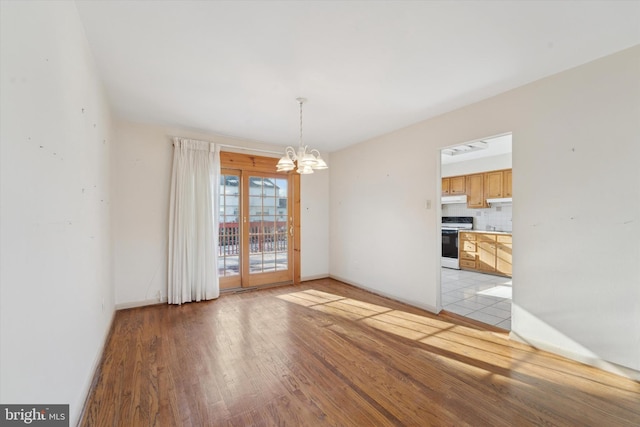 unfurnished dining area featuring light hardwood / wood-style flooring and a chandelier