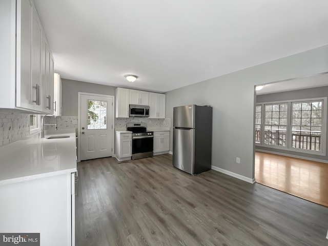 kitchen with sink, white cabinetry, tasteful backsplash, dark hardwood / wood-style flooring, and appliances with stainless steel finishes