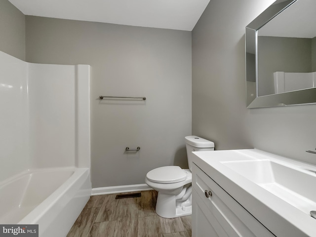 full bathroom featuring washtub / shower combination, vanity, and toilet