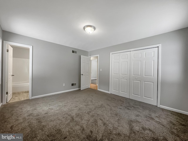 unfurnished bedroom with ensuite bathroom, carpet floors, and a closet