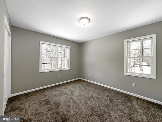 spare room with dark carpet