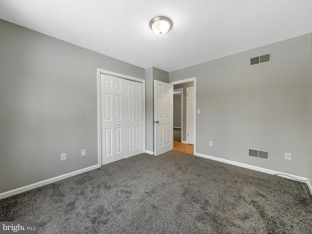 unfurnished bedroom with a closet and carpet flooring