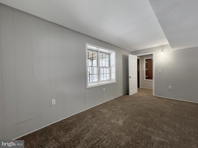 unfurnished room with dark colored carpet