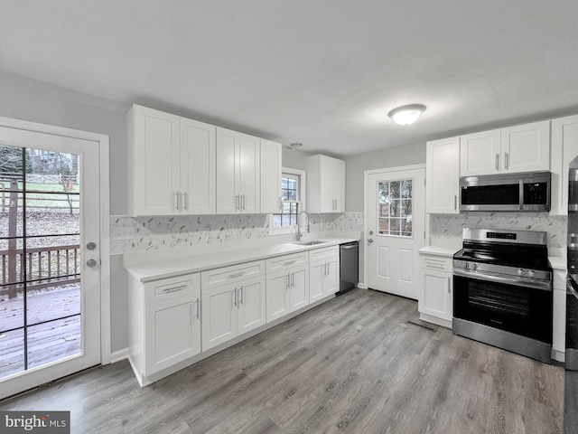 kitchen with stainless steel appliances, white cabinets, and sink