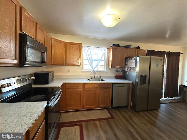 kitchen featuring appliances with stainless steel finishes, dark hardwood / wood-style flooring, and sink