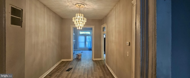 hall featuring dark hardwood / wood-style flooring and a notable chandelier