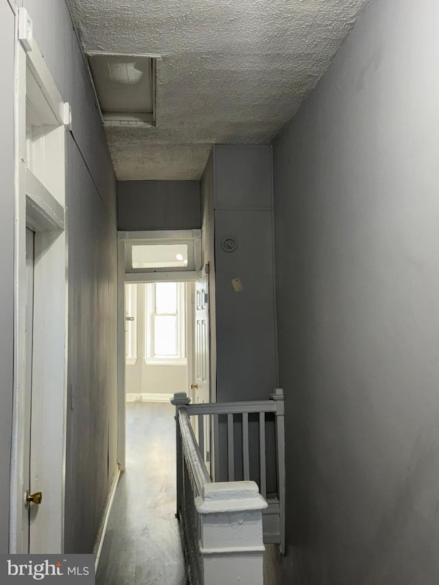 hallway with a textured ceiling and concrete flooring