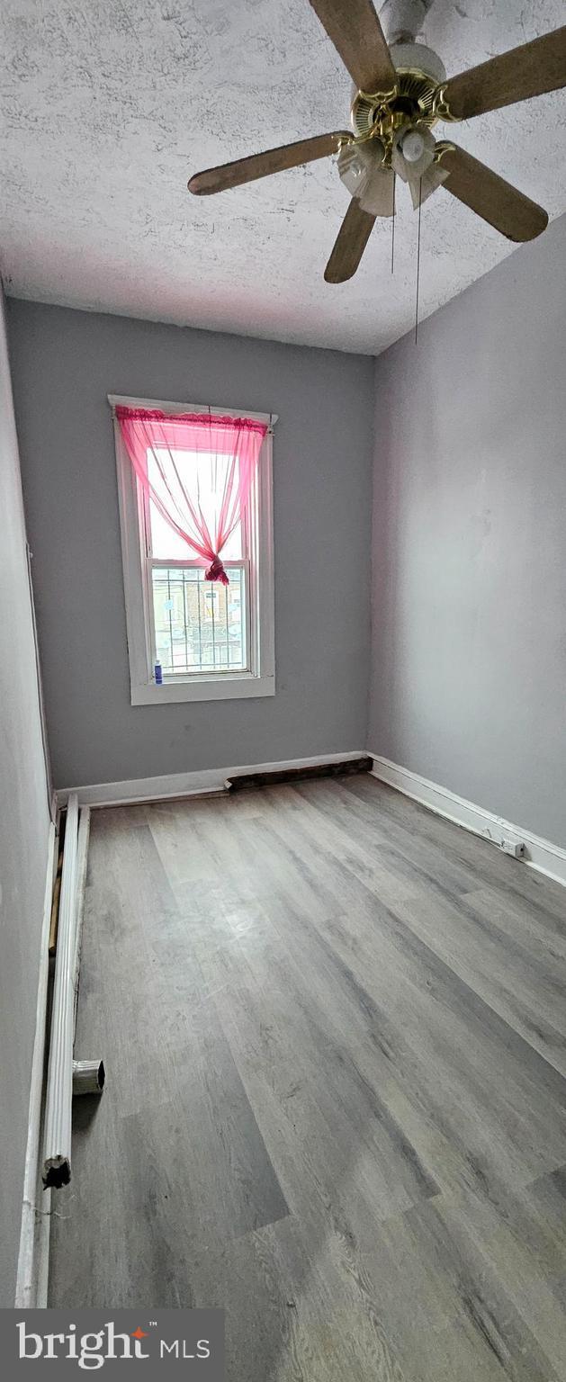 spare room featuring a textured ceiling and hardwood / wood-style floors