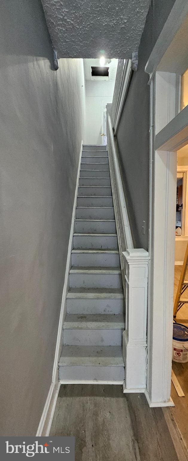 staircase with wood-type flooring