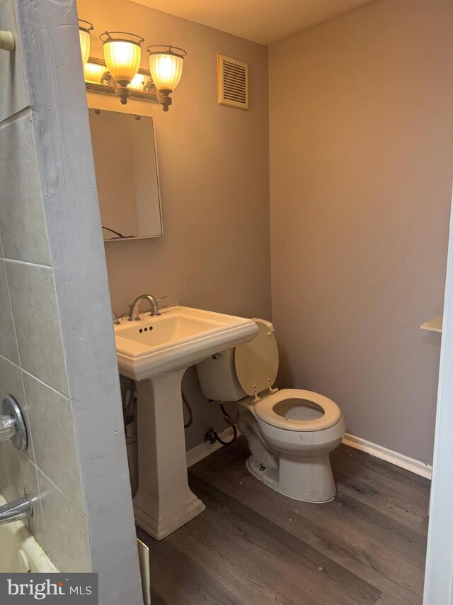 bathroom featuring toilet and wood-type flooring