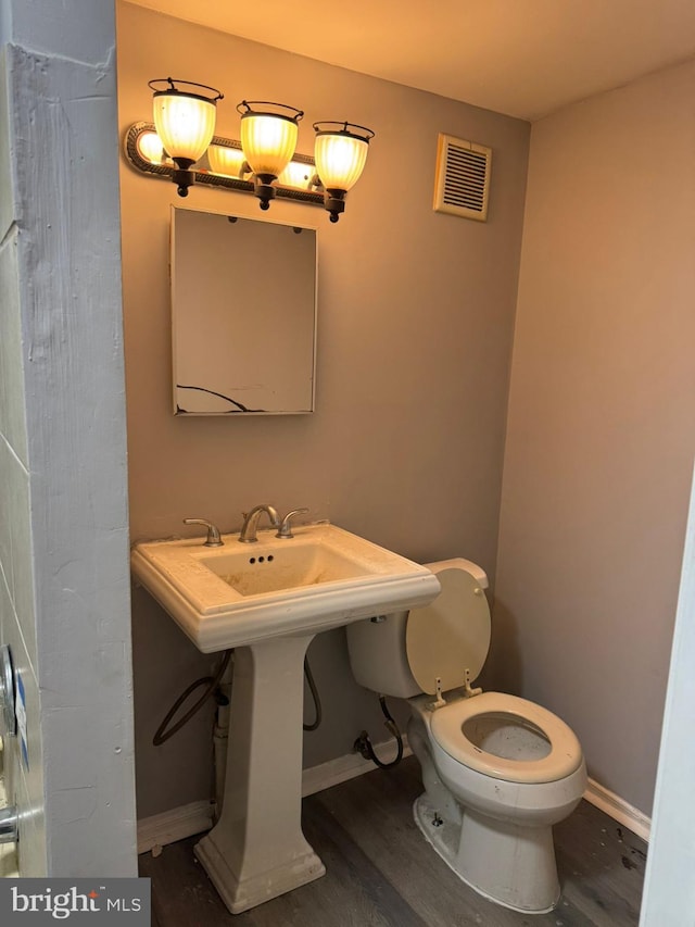 bathroom featuring toilet and wood-type flooring