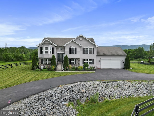 raised ranch featuring a garage and a front lawn