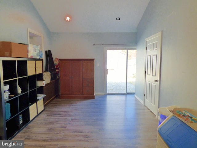 interior space featuring lofted ceiling and light hardwood / wood-style flooring