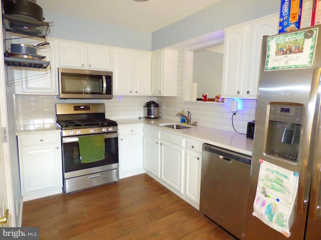 kitchen with appliances with stainless steel finishes, white cabinets, decorative backsplash, and sink