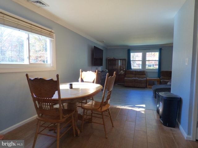 dining area with ornamental molding and dark hardwood / wood-style floors