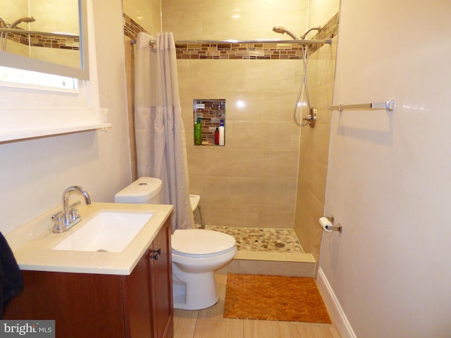 bathroom featuring toilet, walk in shower, and vanity