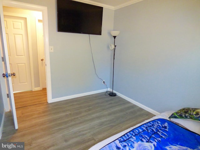 bedroom featuring hardwood / wood-style floors and crown molding