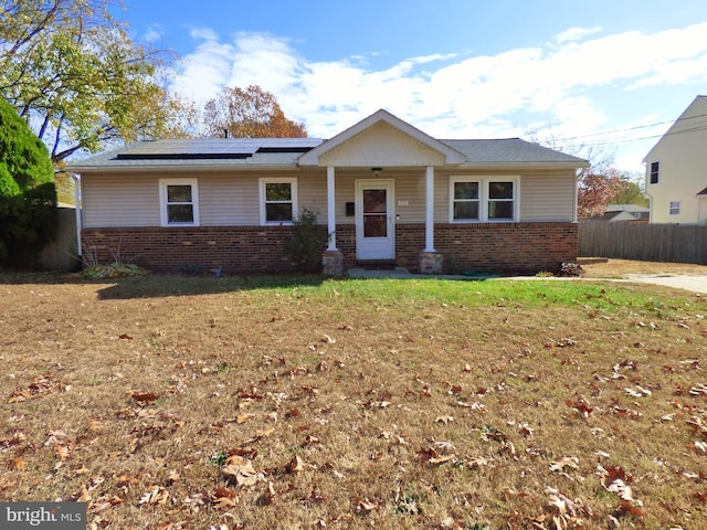 view of front of home with solar panels and a front lawn