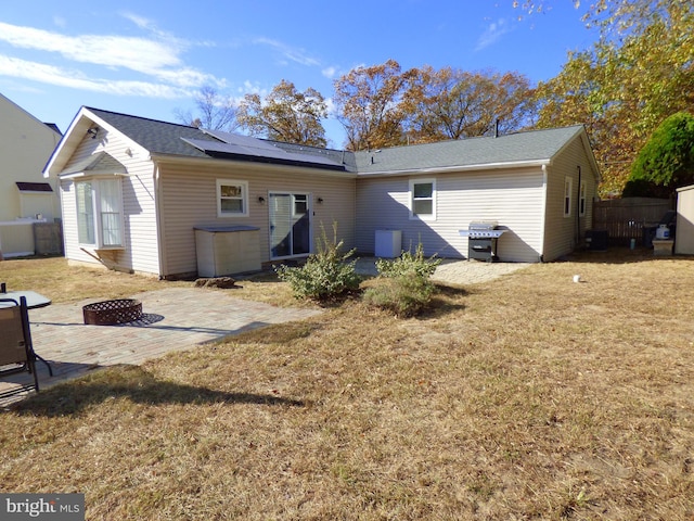 back of house featuring an outdoor fire pit, a patio area, and a yard