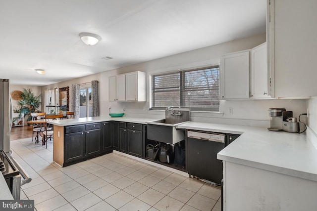 kitchen featuring sink, white cabinetry, dishwasher, kitchen peninsula, and stainless steel fridge