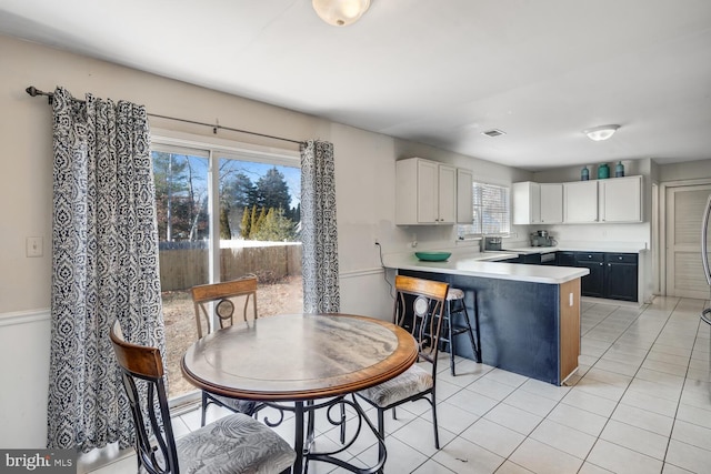 kitchen with a wealth of natural light, white cabinetry, a breakfast bar area, and kitchen peninsula