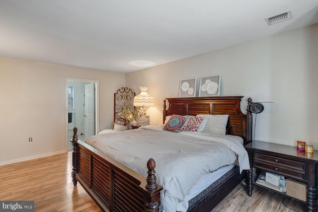 bedroom featuring light hardwood / wood-style flooring and connected bathroom