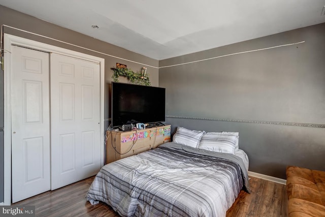 bedroom with dark wood-type flooring and a closet