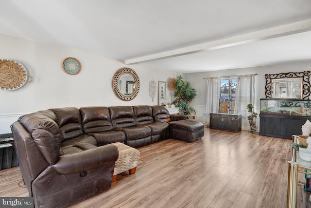 living room with light wood-type flooring and beam ceiling