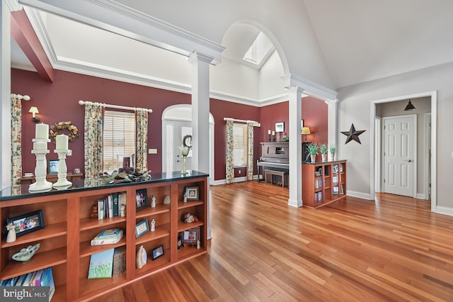 foyer entrance with wood-type flooring and decorative columns