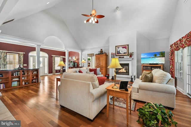 living room with high vaulted ceiling, ceiling fan, dark wood-type flooring, and ornate columns