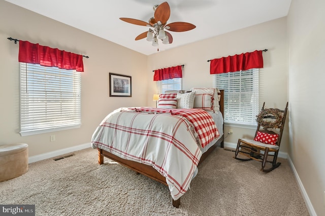 carpeted bedroom featuring ceiling fan and multiple windows