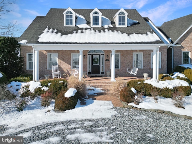 cape cod house featuring a porch