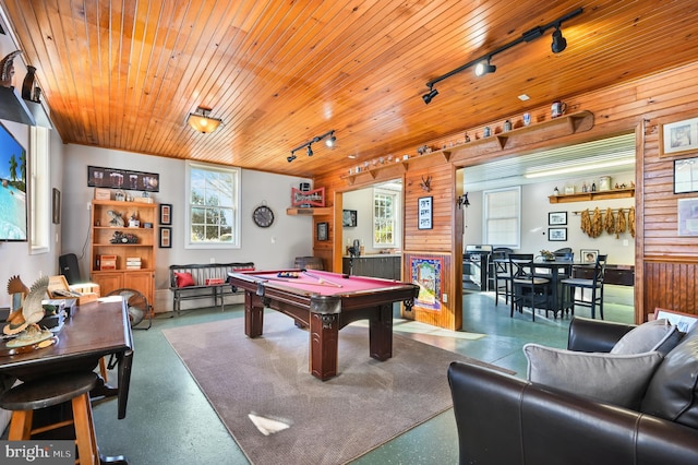 game room featuring wooden ceiling, rail lighting, pool table, and wood walls