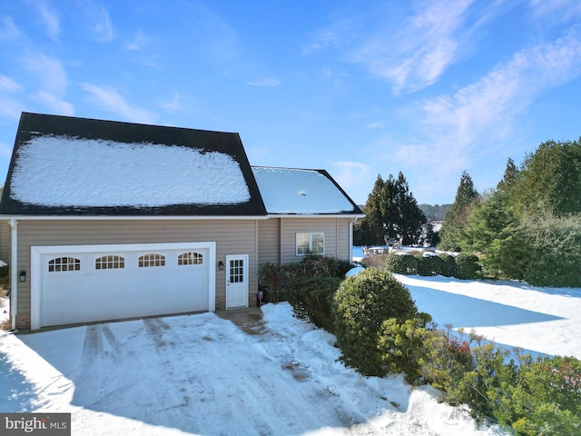 snow covered property featuring a garage