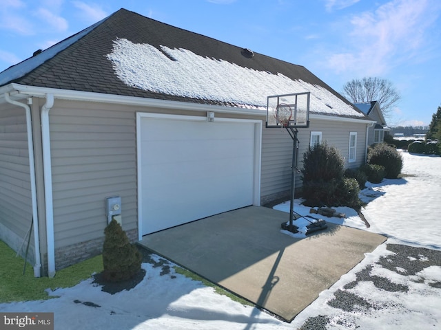 view of snowy exterior featuring a garage