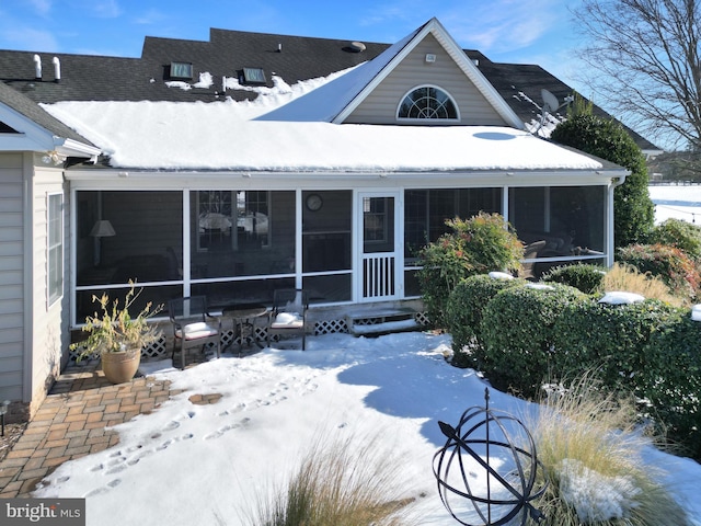 snow covered property featuring a sunroom