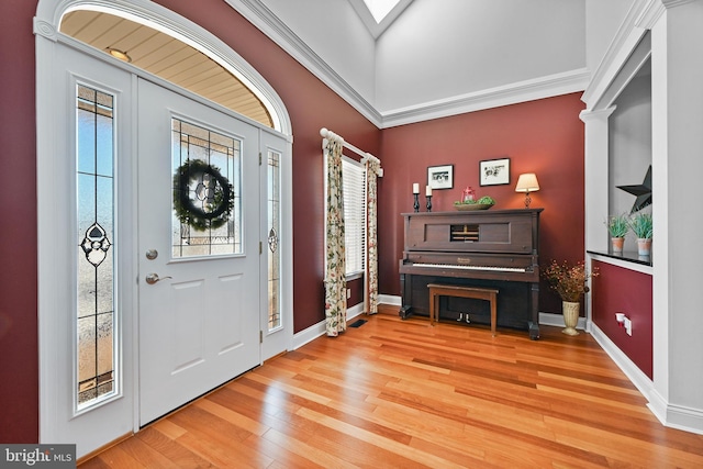 entryway with hardwood / wood-style flooring, lofted ceiling, and ornamental molding