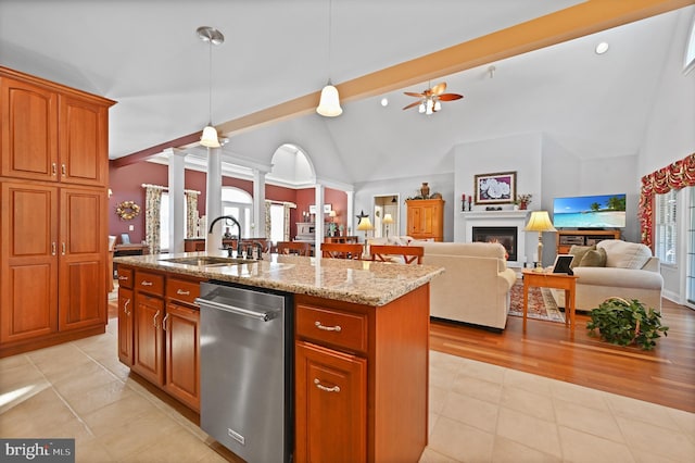 kitchen featuring ornate columns, ceiling fan, decorative light fixtures, a kitchen island with sink, and sink