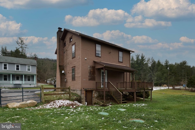 rear view of house featuring a deck and a yard