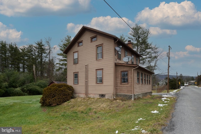 view of side of property with a lawn