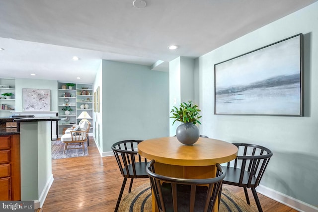 dining space featuring built in features and light hardwood / wood-style flooring