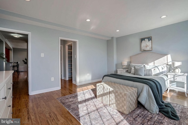 bedroom with a spacious closet and hardwood / wood-style floors