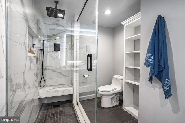 bathroom featuring toilet and a shower with shower door